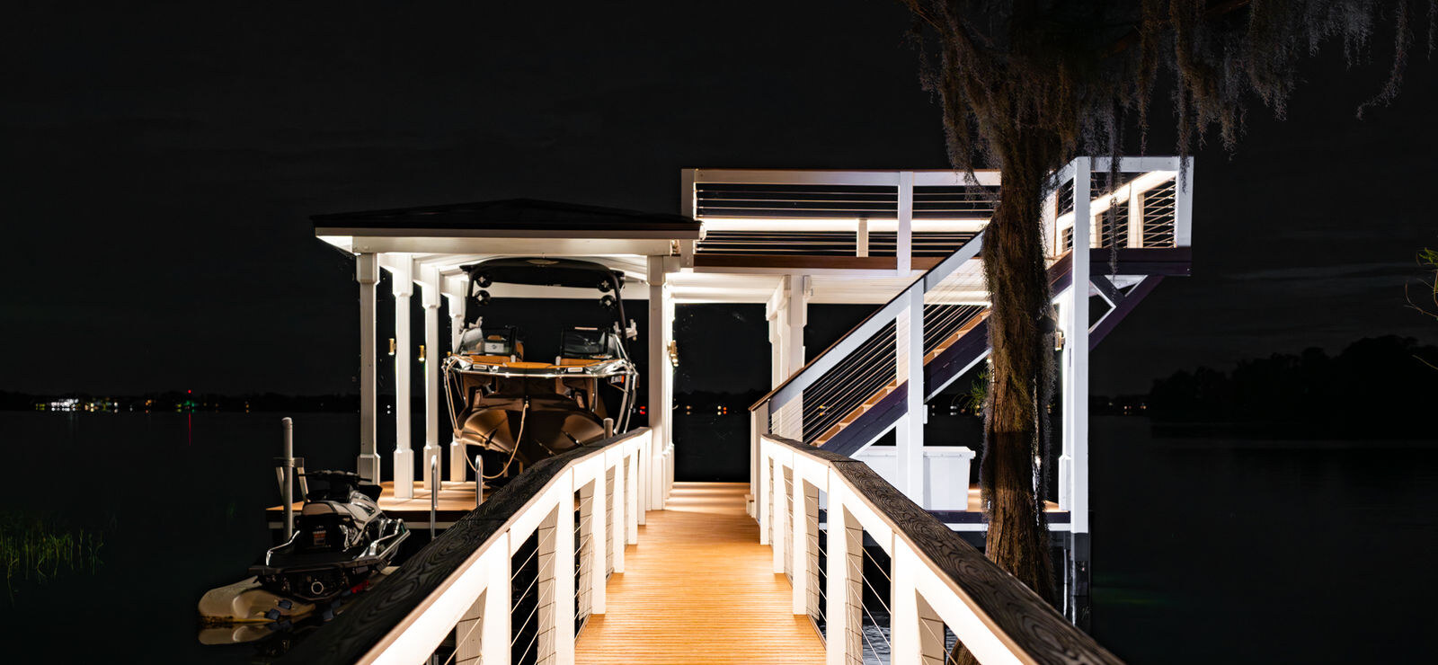 Illuminated AmeriDex dock and walkway at night with lake view